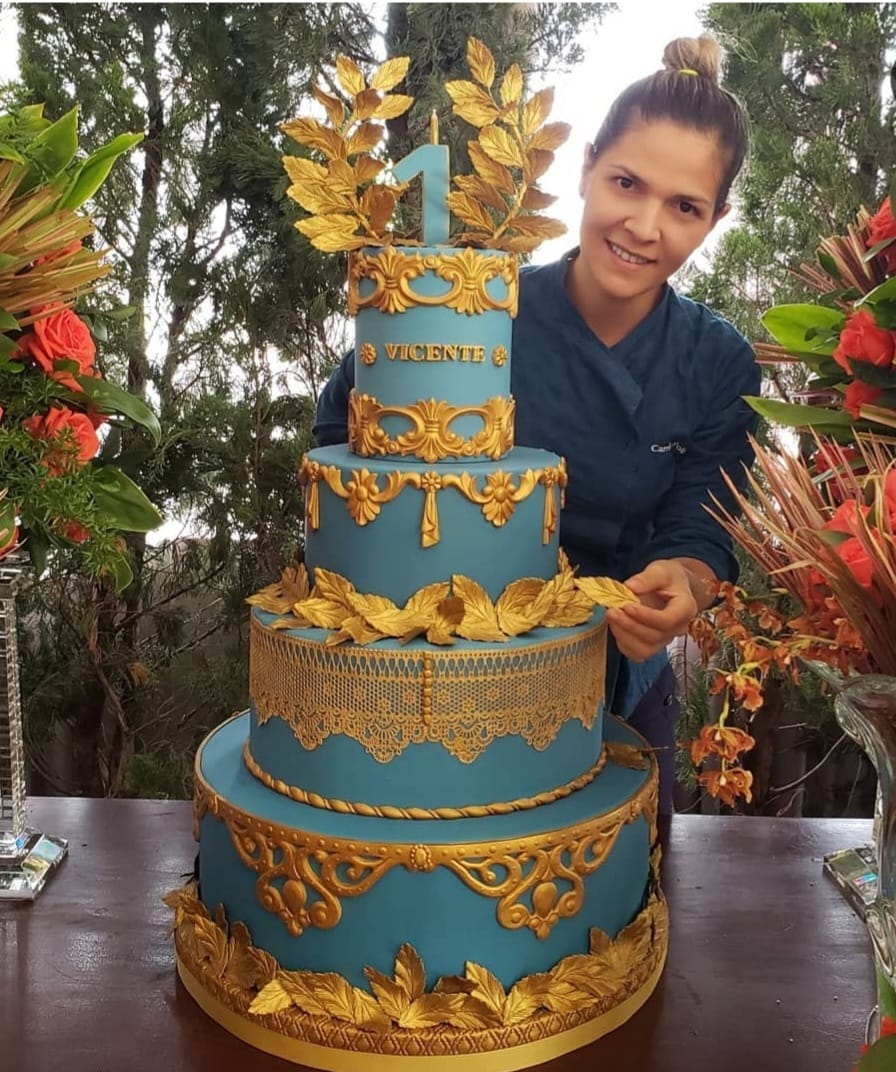 Mila Poli ao lado de um bolo de quatro andares